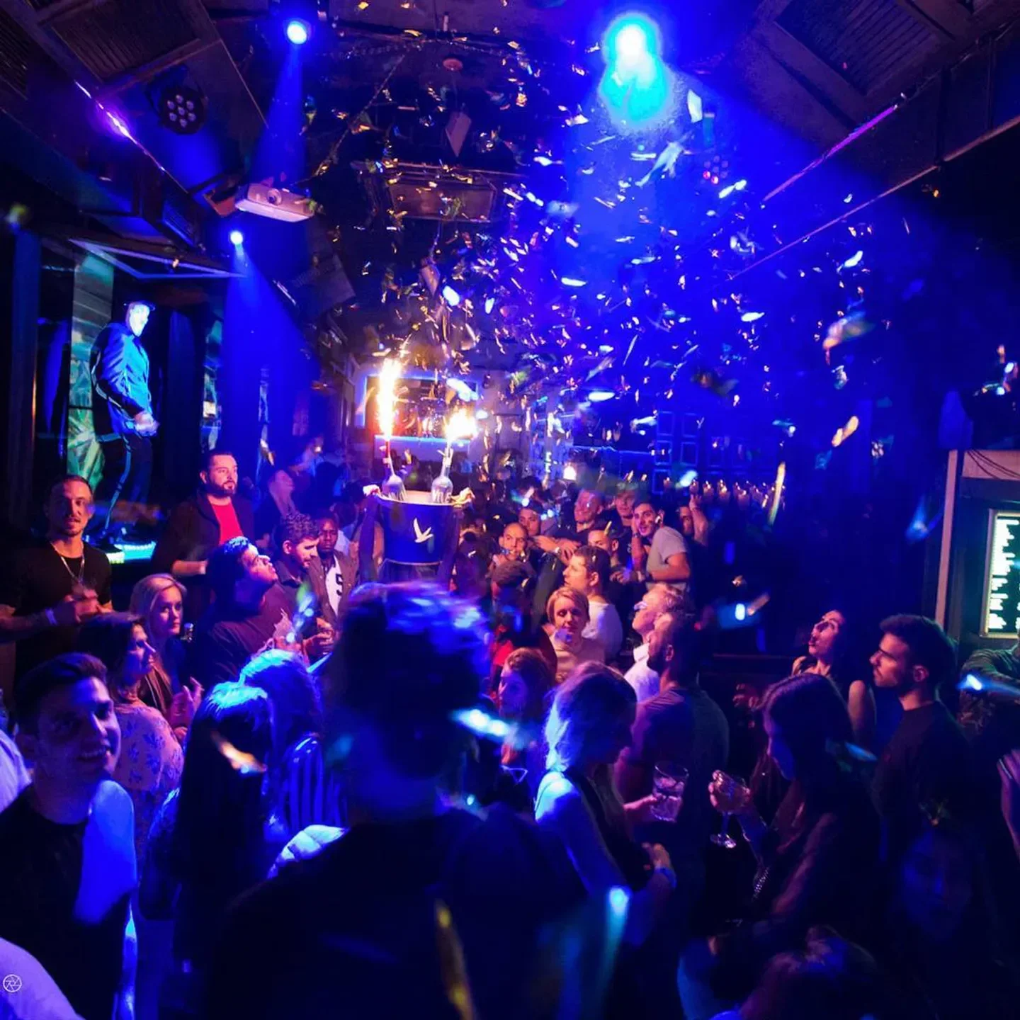 Energetic party at M1 Lounge and Club in Prague, confetti and happy crowd.