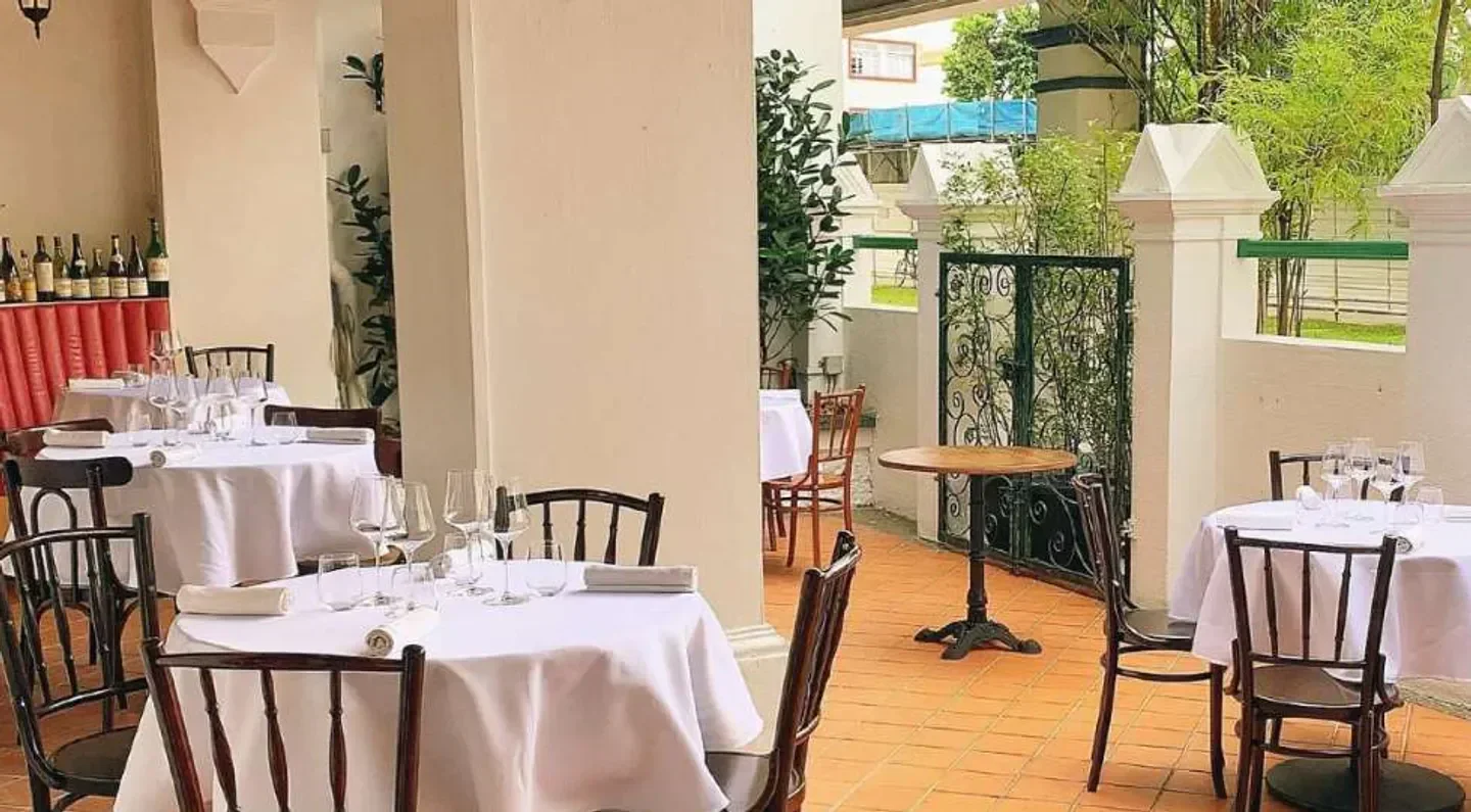 Outdoor dining area at Ma Cuisine Singapore restaurant, with elegant tables and chairs.