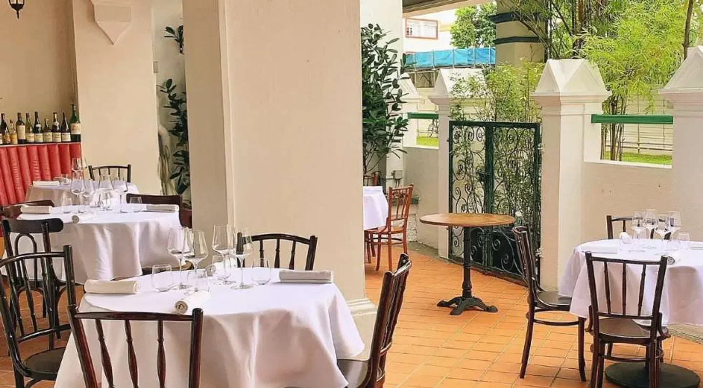 Outdoor dining area at Ma Cuisine Singapore restaurant, with elegant tables and chairs.