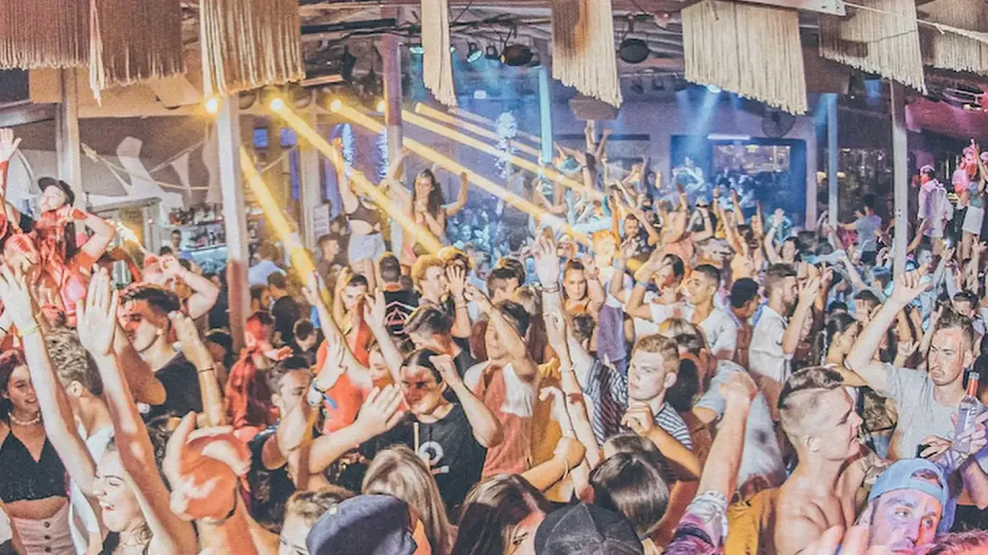 Energetic crowd partying at Madon nightclub in Mykonos, Greece with lights and music