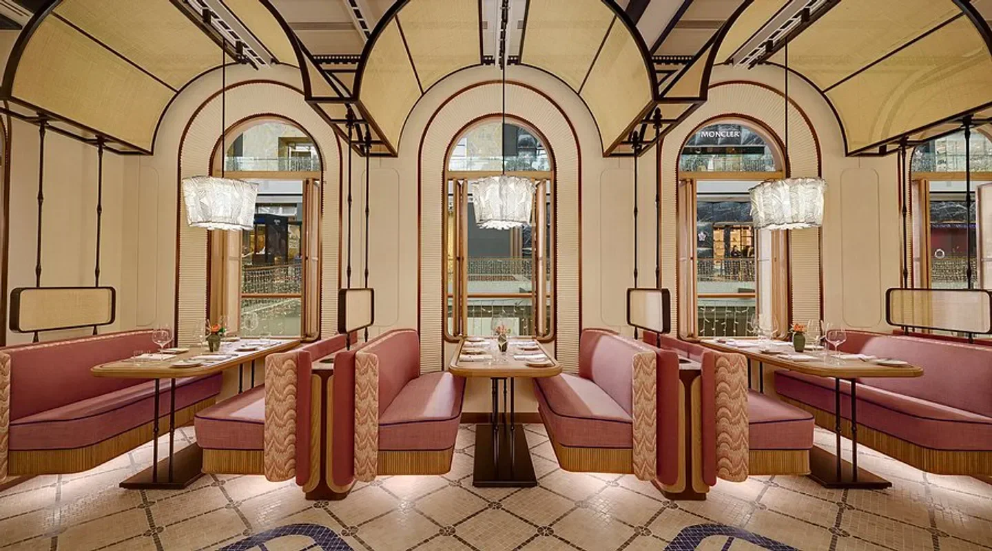 Interior of Maison Boulud restaurant in Singapore, featuring pink seating and stylish design.