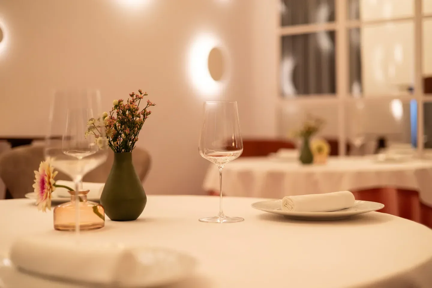 Elegant table setting at Maison Dubois restaurant in Paris with floral decorations.