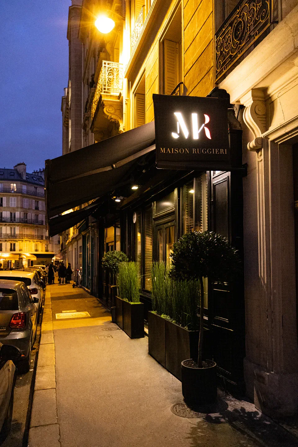 Exterior of Maison Ruggieri restaurant in Paris at dusk, with street view.
