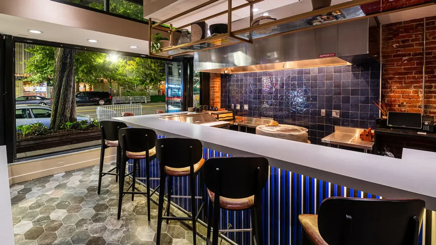 Interior view of MAIZ 64 in Washington, featuring bar seating and kitchen area.