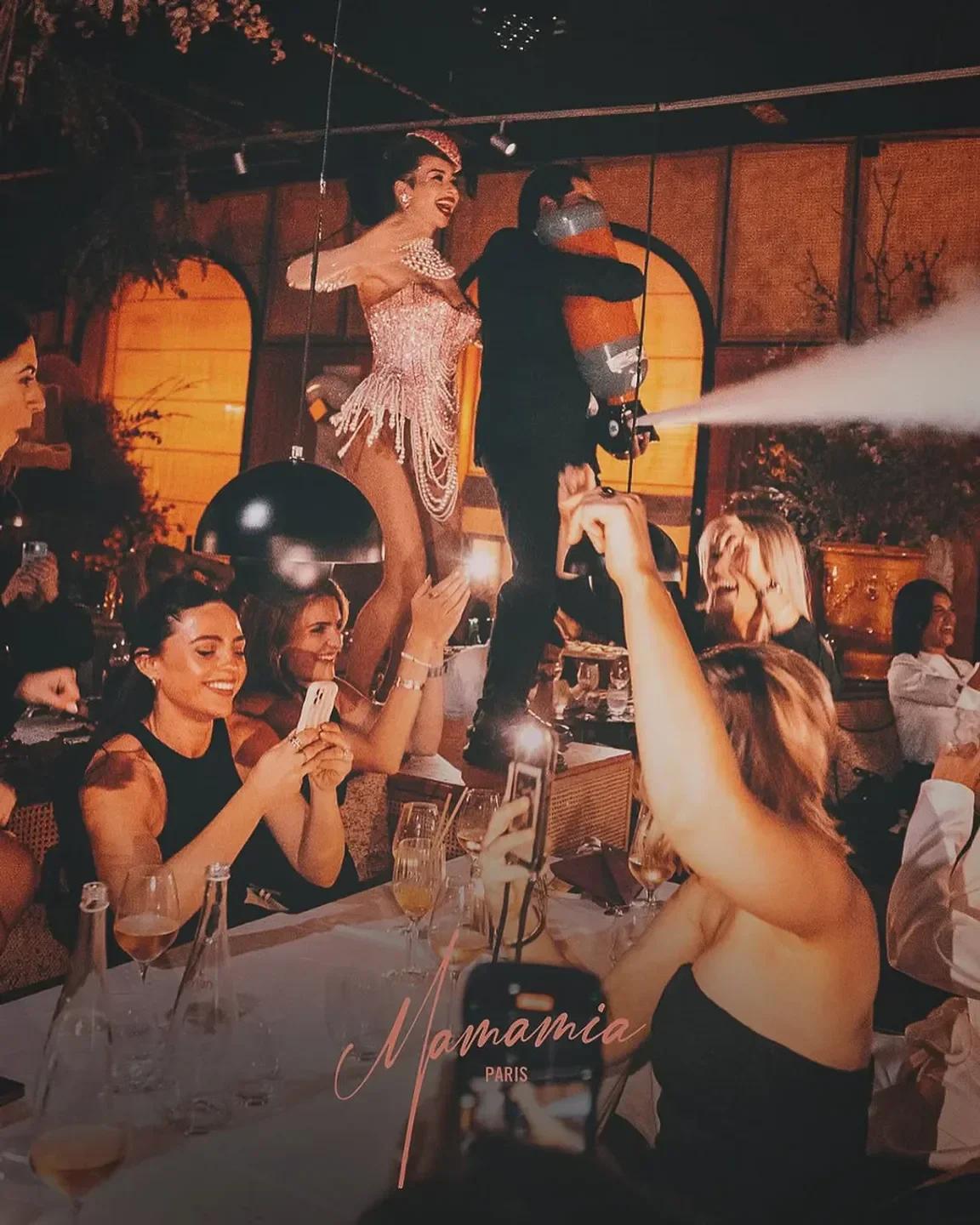 Entertaining show at Mamamia Paris restaurant, guests taking photos, lively atmosphere.