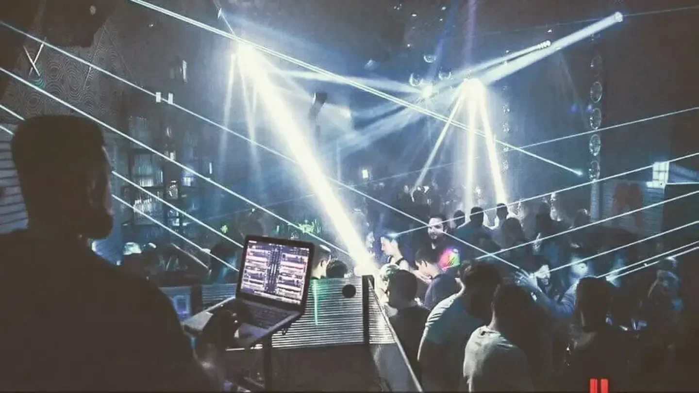 DJ at Mamounia Club in Santorini, with laser lights and a crowded dance floor.