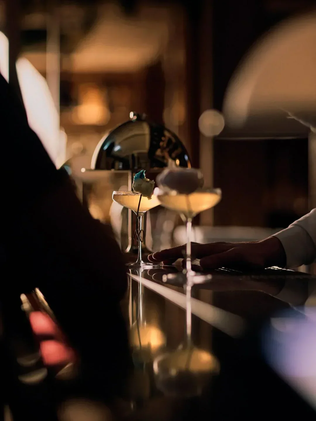 Elegant cocktails at Mandarin Grill Bar in Hong Kong, with moody lighting and detailed presentation.