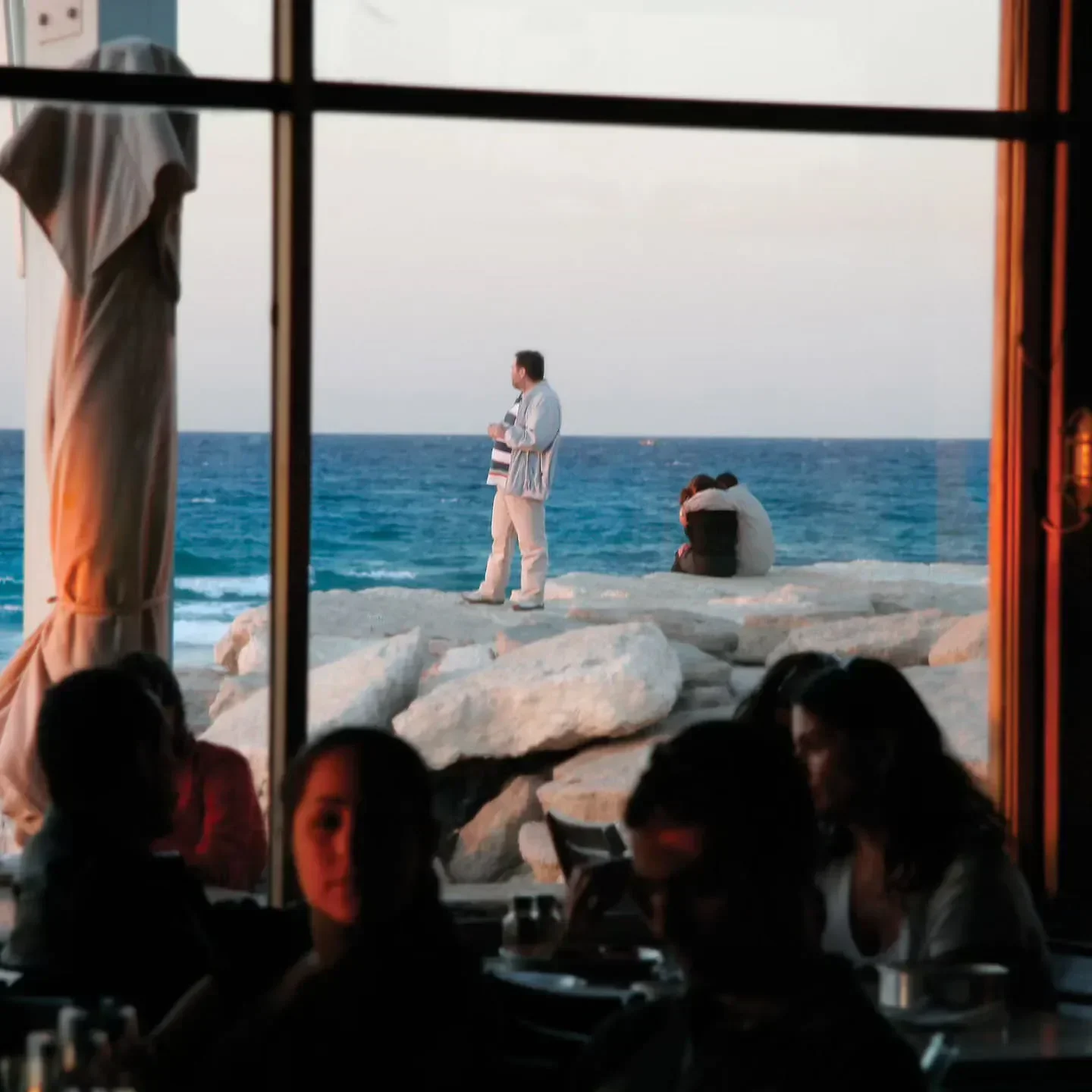 Seaside view from Manta Ray restaurant in Tel Aviv, with diners and ocean scenery