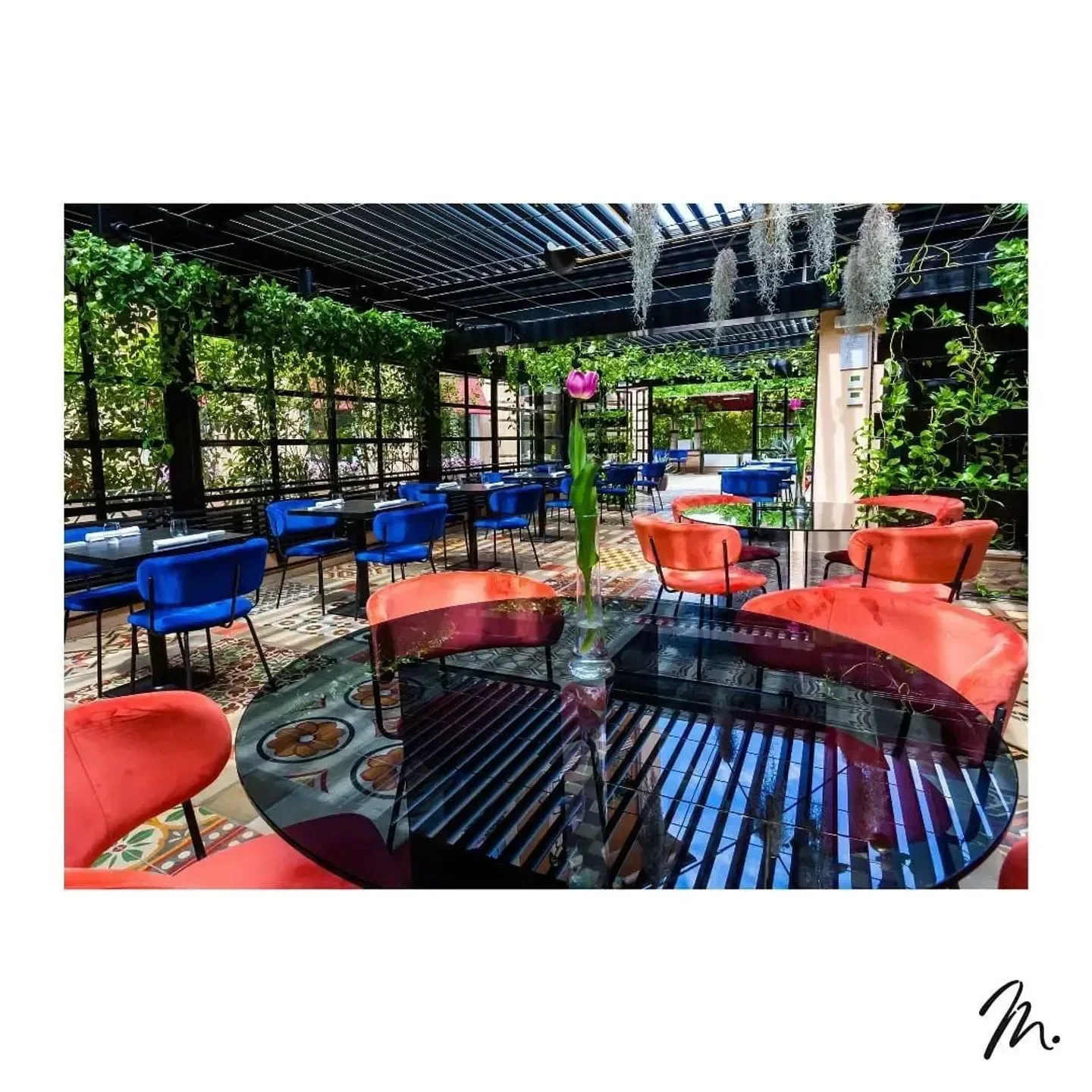 Stylish dining area at Marco Martini Restaurant in Rome, with vibrant decor and floral accents.