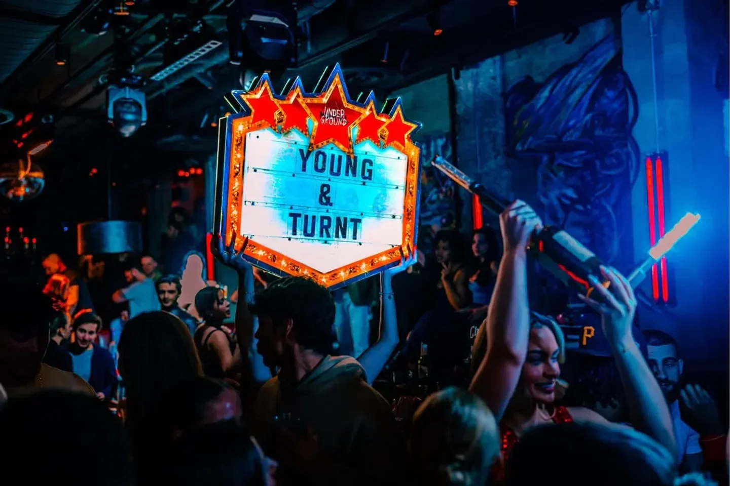 Nightclub scene at Mariel Underground in Boston with people and sign that says Young & Turnt
