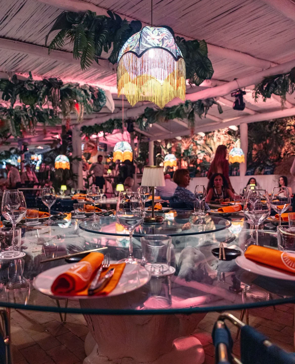 Marro restaurant in Porto Cervo features a vibrant tropical interior with lush plants and elegant table settings.