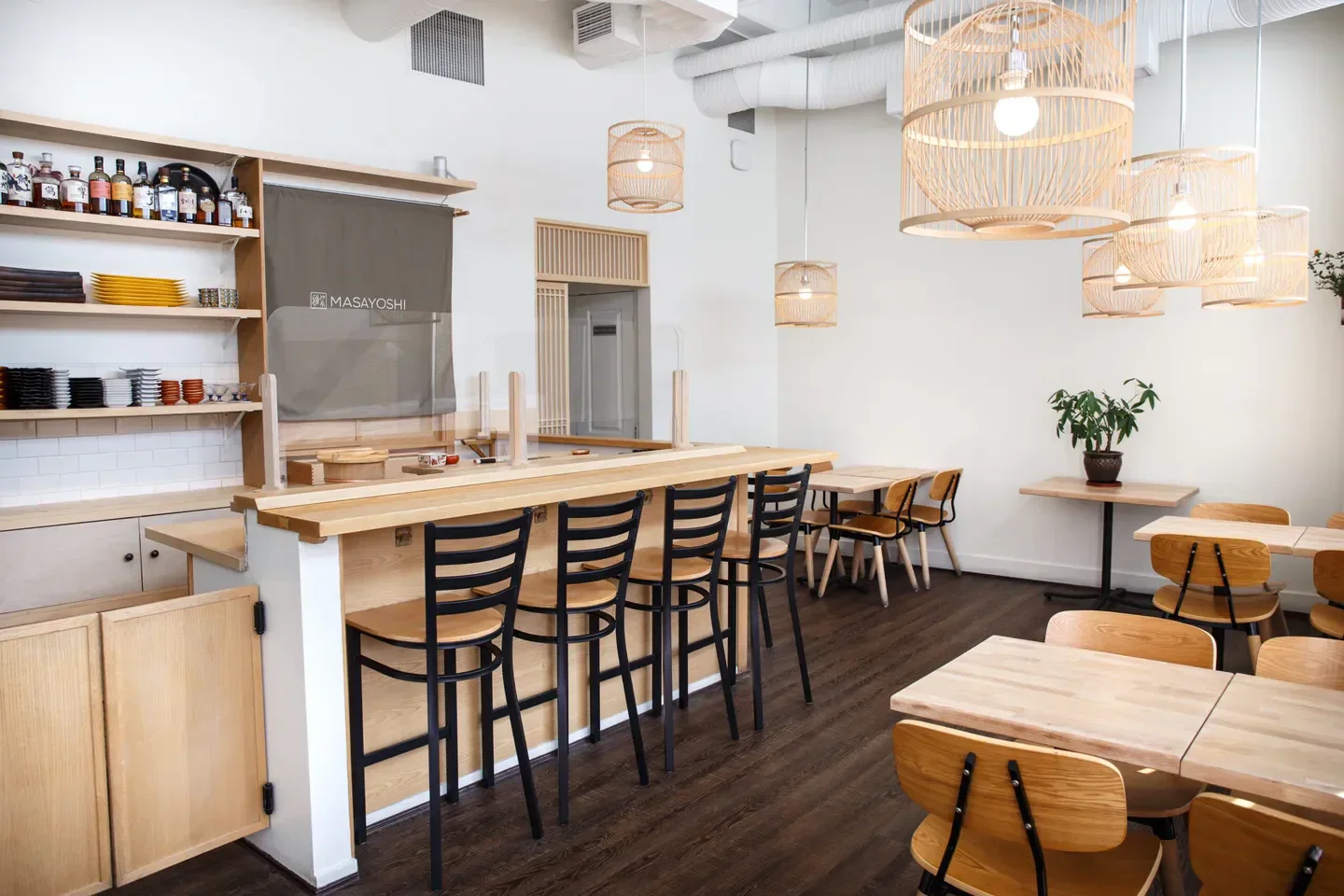 Modern interior of Masayoshi restaurant in Vancouver, with bar seating and wooden decor.