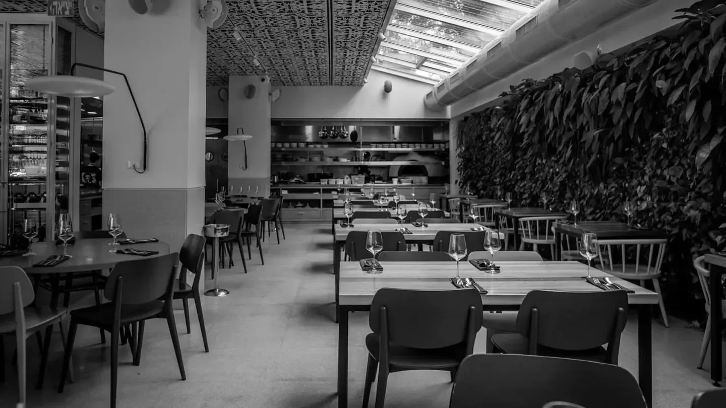 Interior of Mashya restaurant in Tel Aviv, featuring dining tables and a modern design.