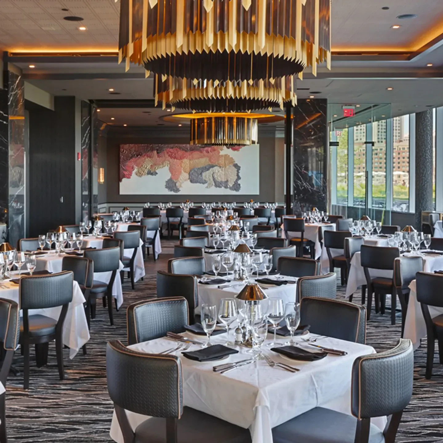Elegant dining room interior at Mastro's Ocean Club in Boston, with chandeliers and tables.