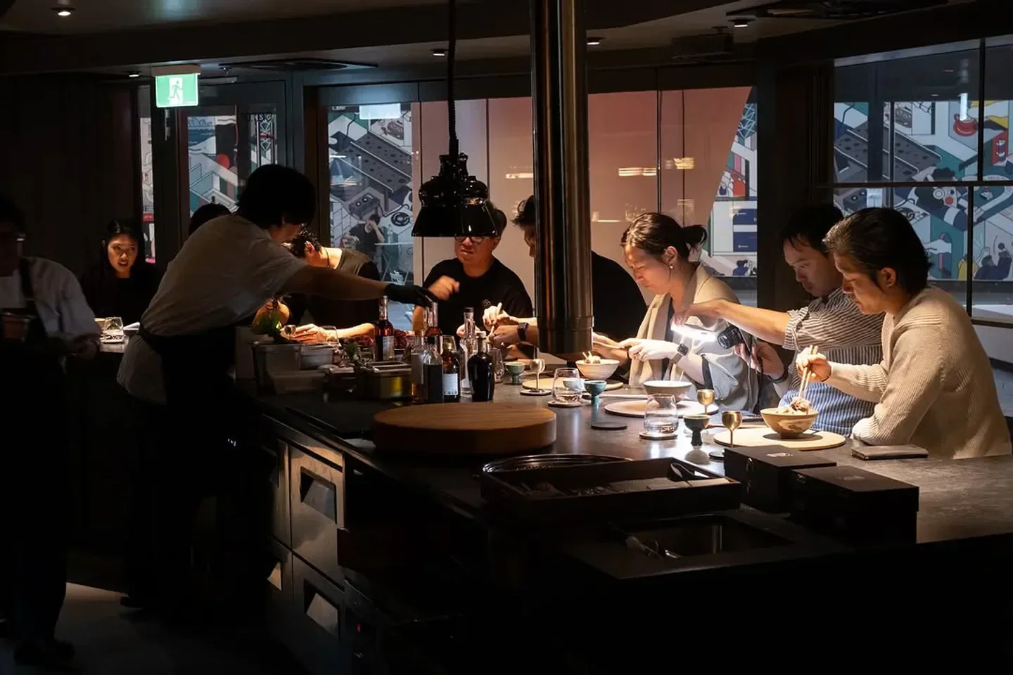 Dining experience at MATKIM restaurant in Sydney. Customers enjoying food with chefs in the background.
