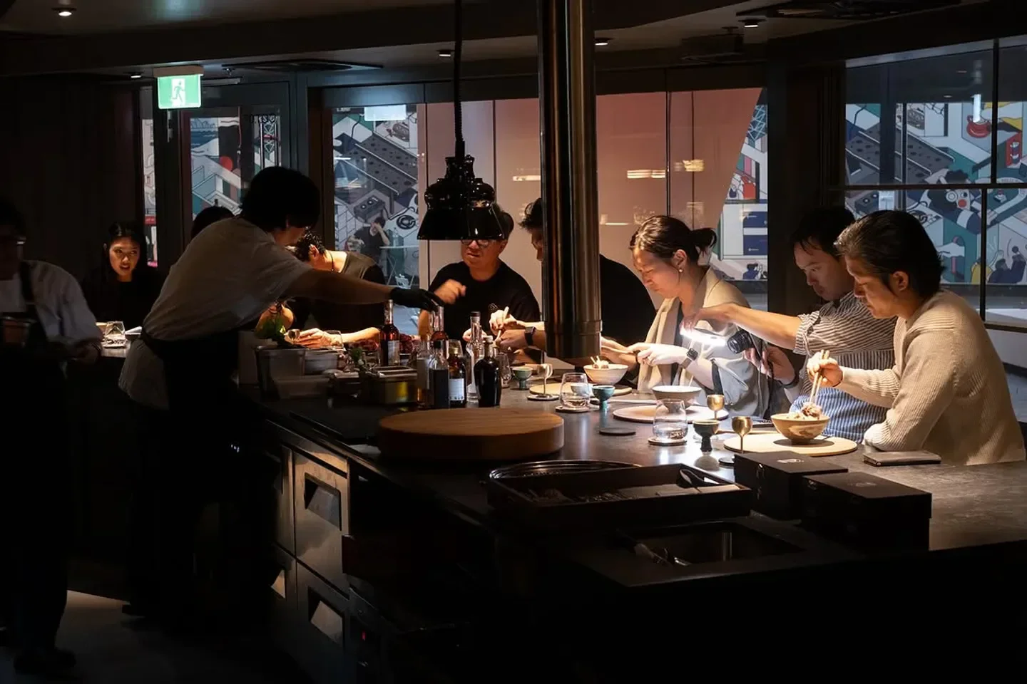 Dining experience at MATKIM restaurant in Sydney. Customers enjoying food with chefs in the background.