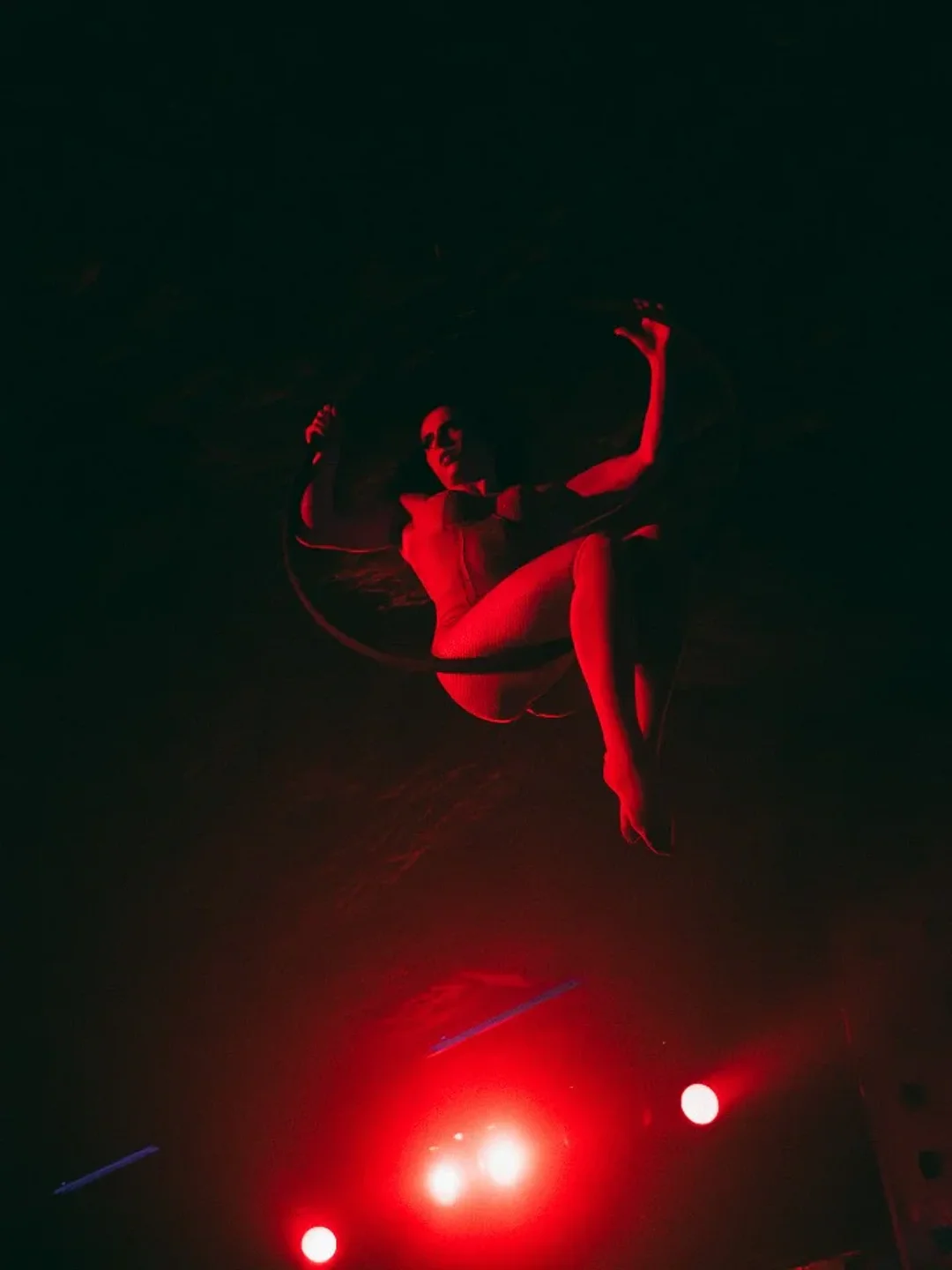 Aerial performer entertains the crowd with a dramatic red-lit act at Medias Puri nightclub in the city.