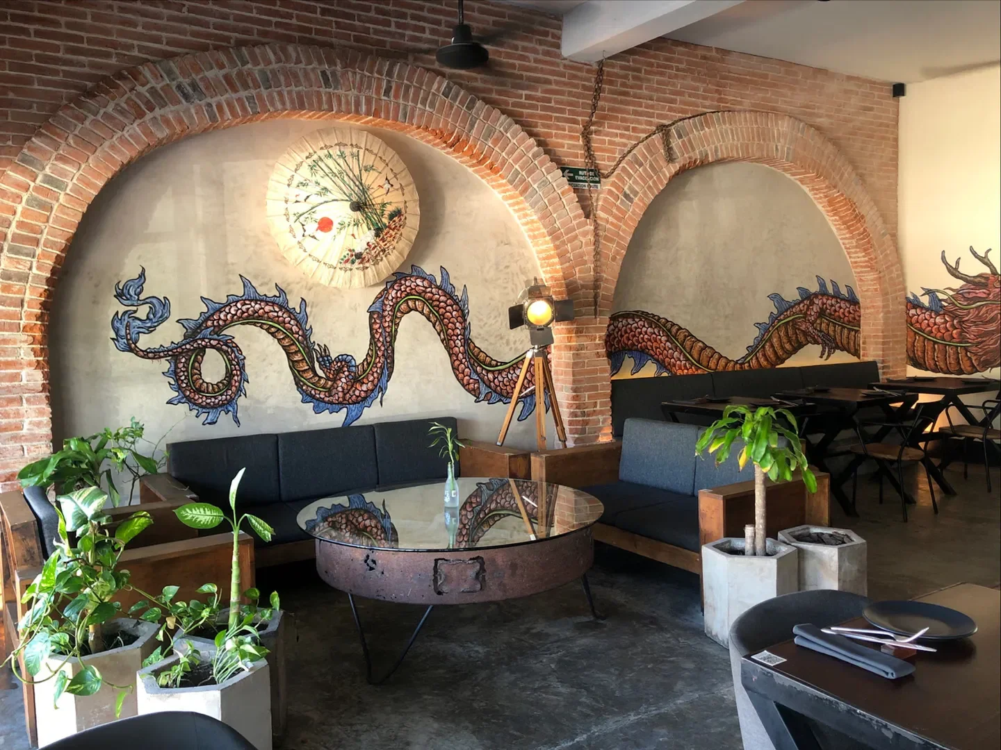 Interior of Mestixa in Tulum, featuring dragon mural and stylish seating.