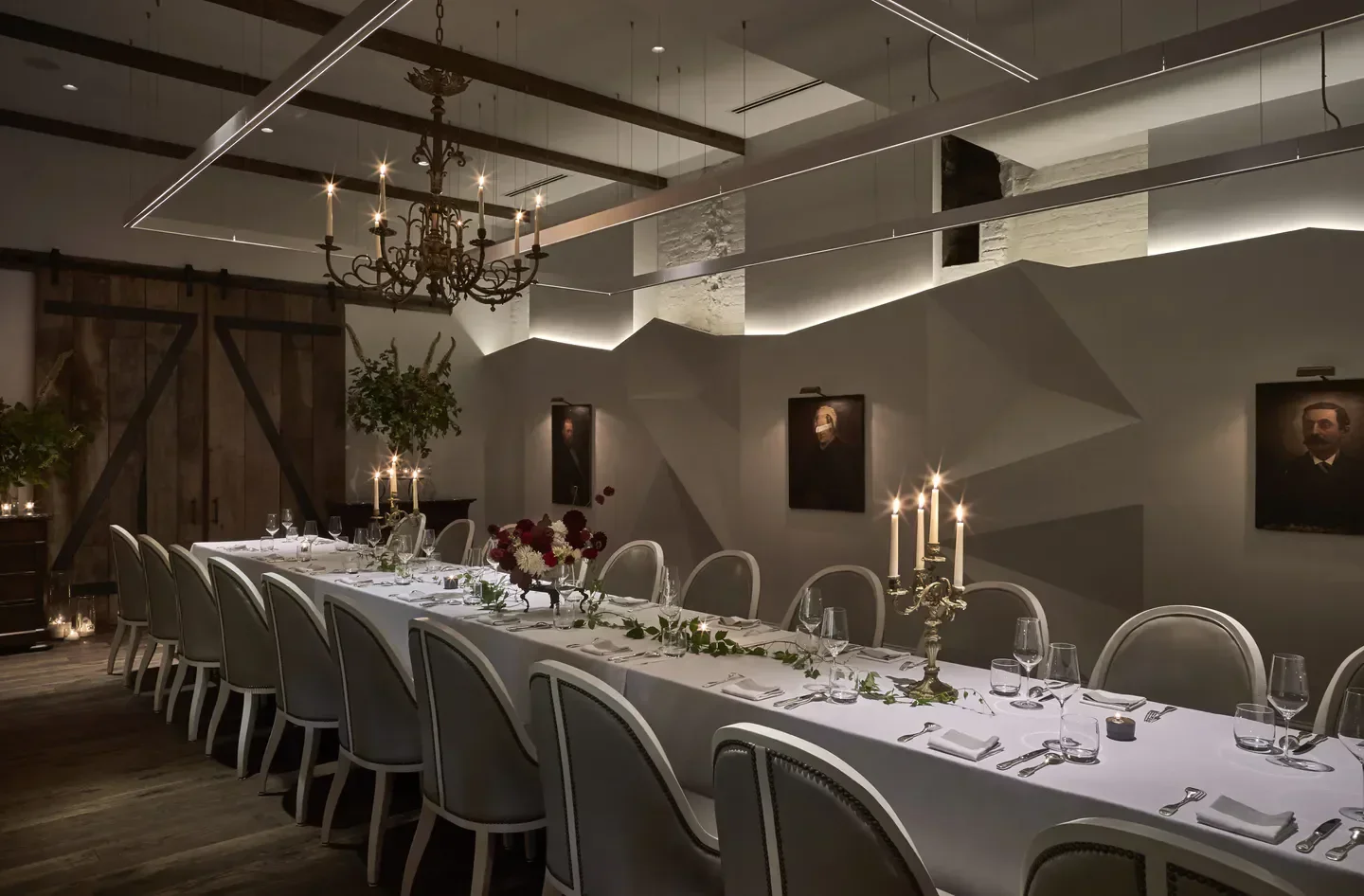 Elegant dining room at Métier, Washington, with long table and antique chandelier