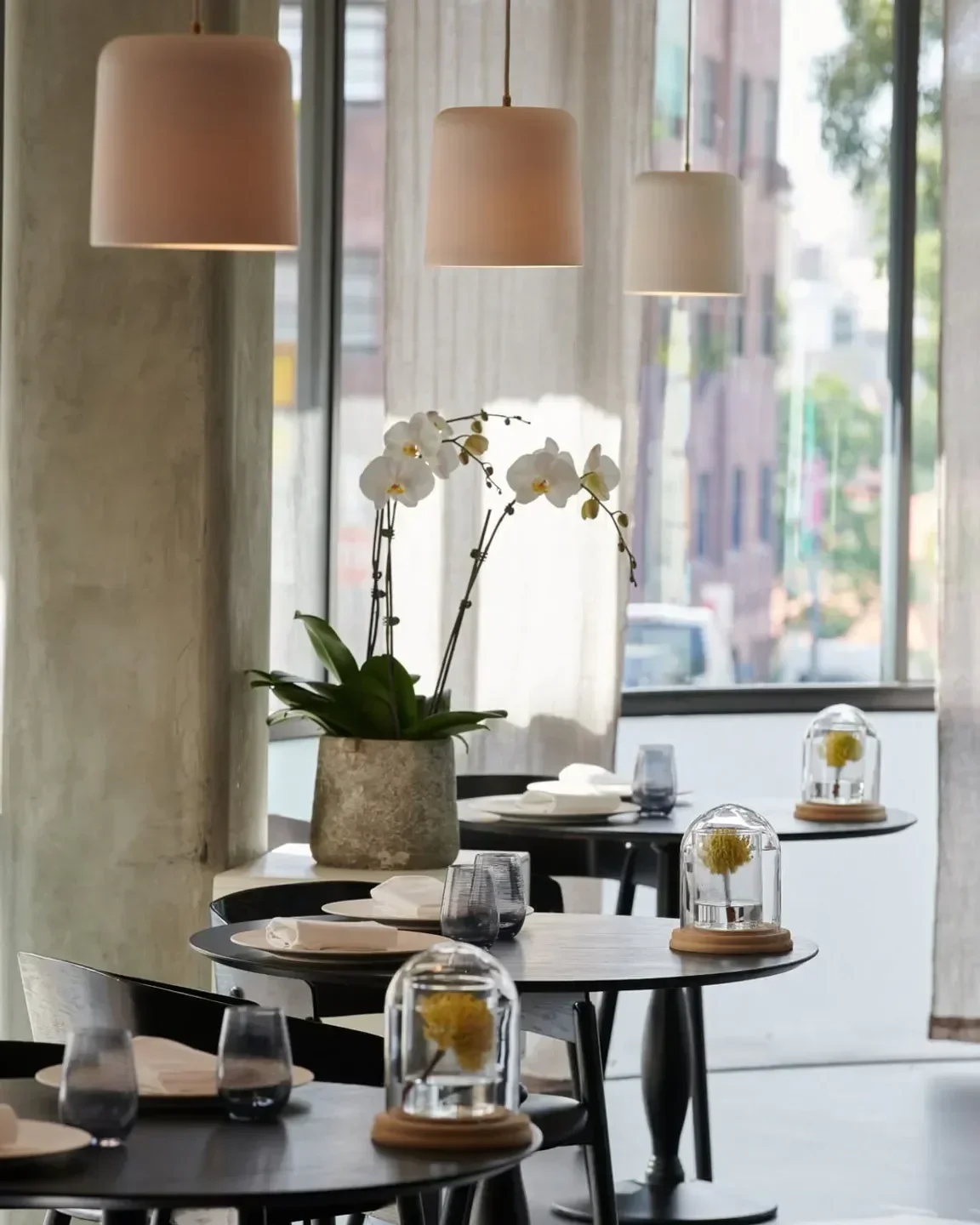 Interior of Métisse restaurant in Sydney, featuring orchid and stylish table settings.