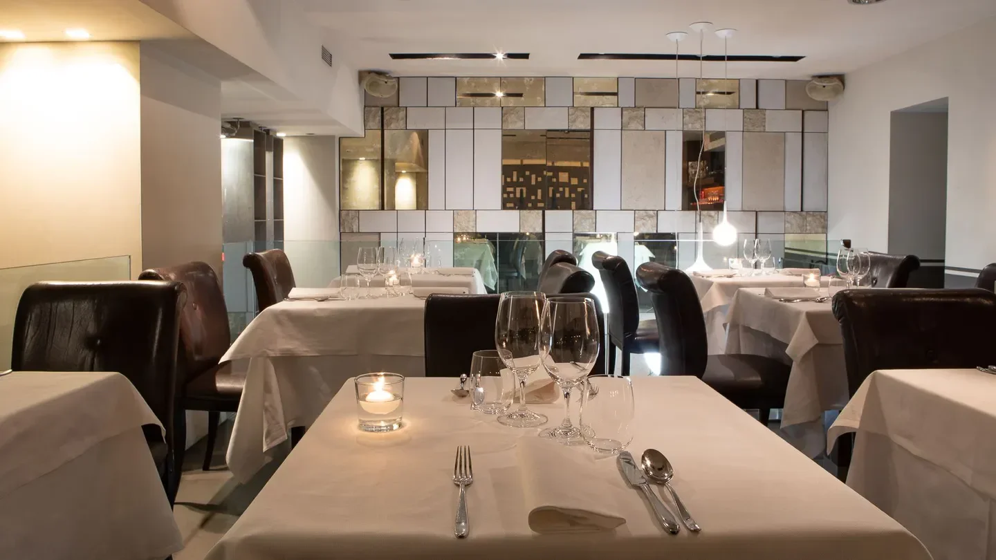 Elegant dining interior at Moma restaurant in Rome, featuring table settings and lighting.