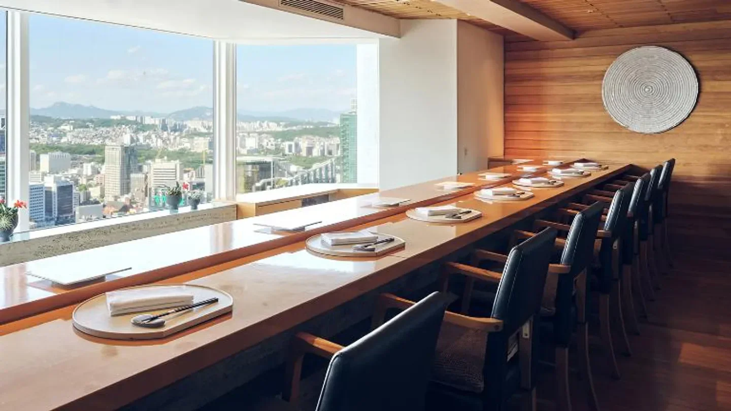 Momoyama restaurant in Seoul with a view of the city skyline through the large windows.