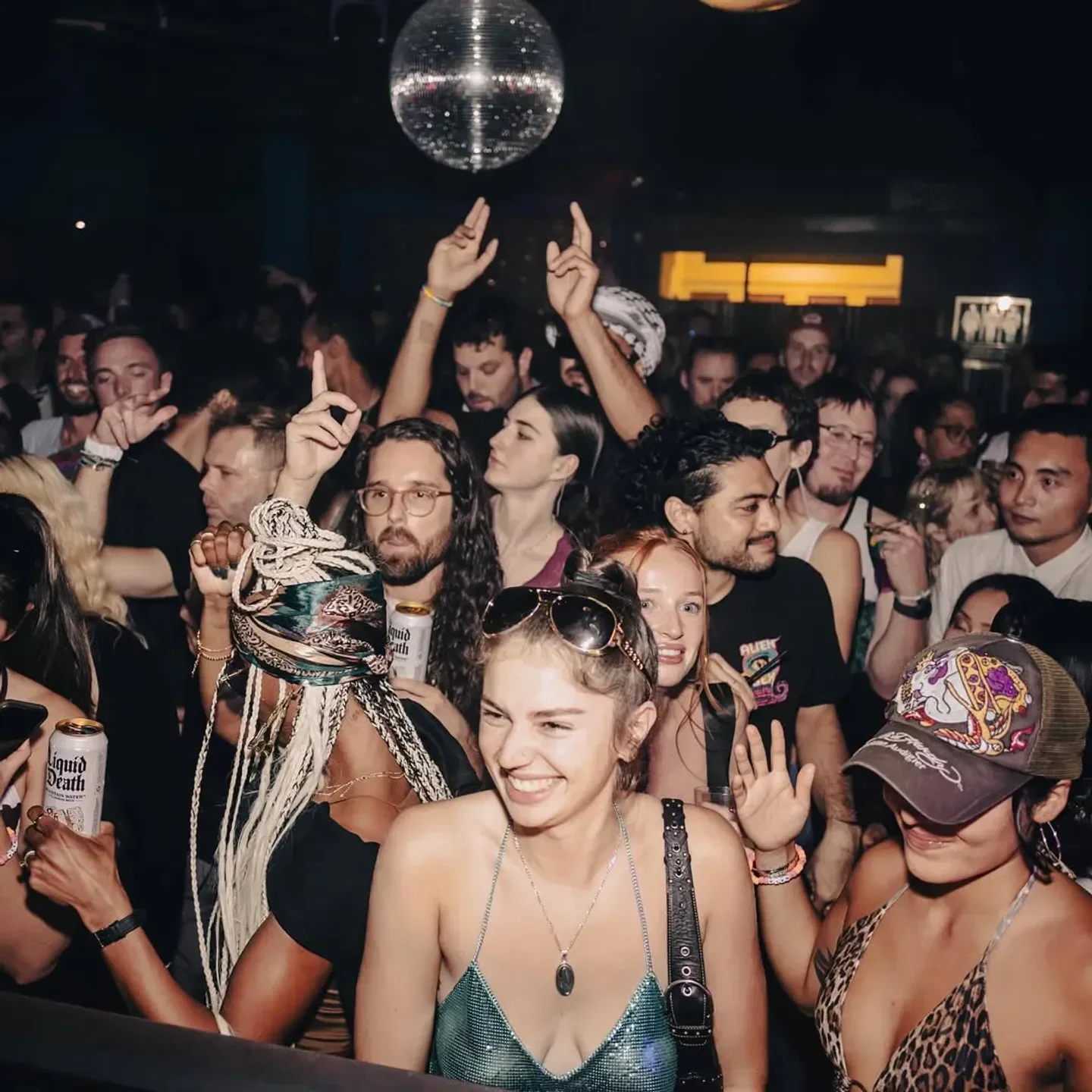 Energetic crowd dancing at Monarch nightclub in San Francisco, with disco ball overhead.