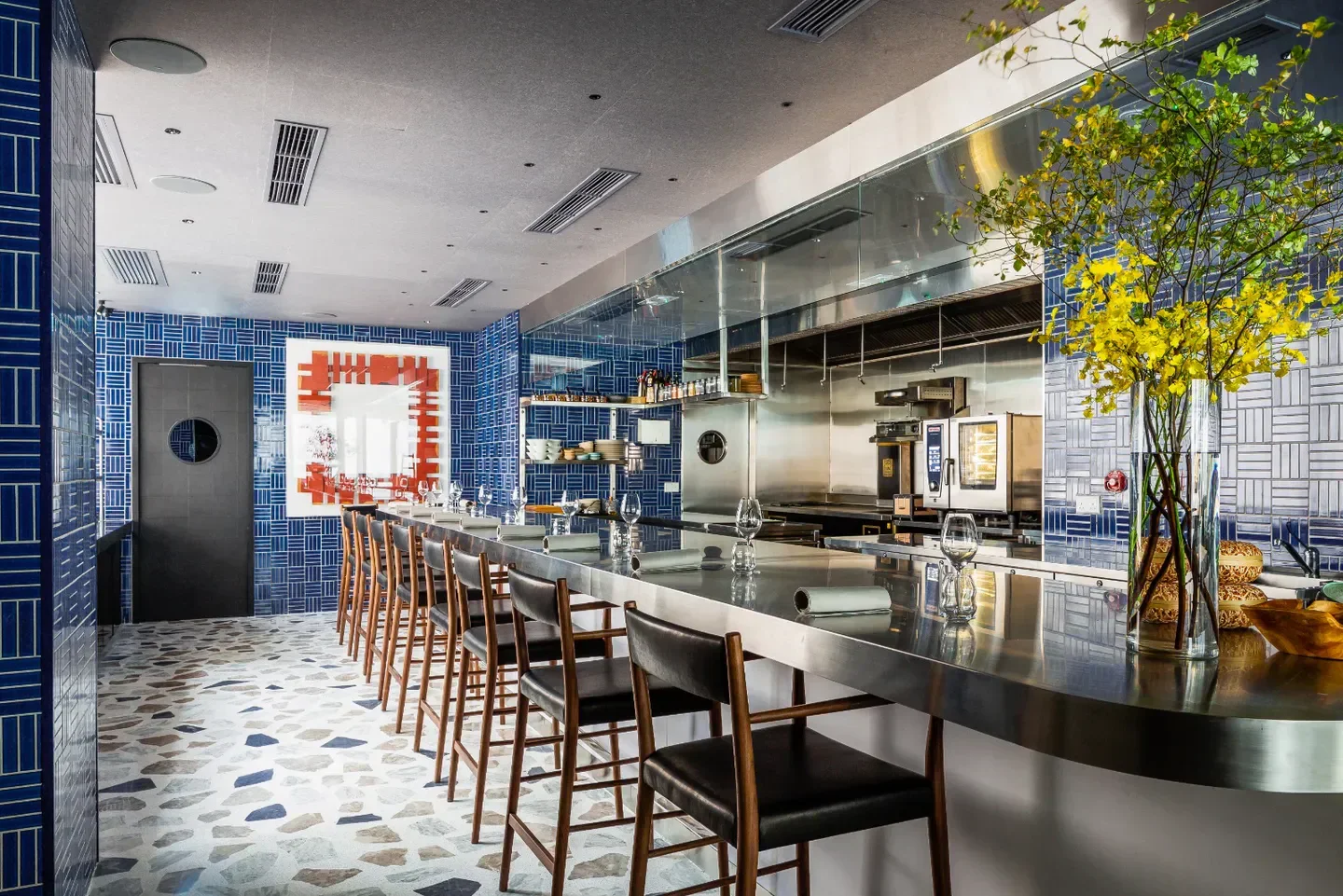 Stylish bar at Mono restaurant in Hong Kong with blue tile decor and modern design.
