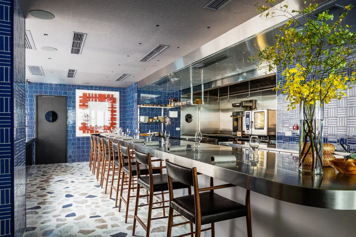 Stylish bar at Mono restaurant in Hong Kong with blue tile decor and modern design.