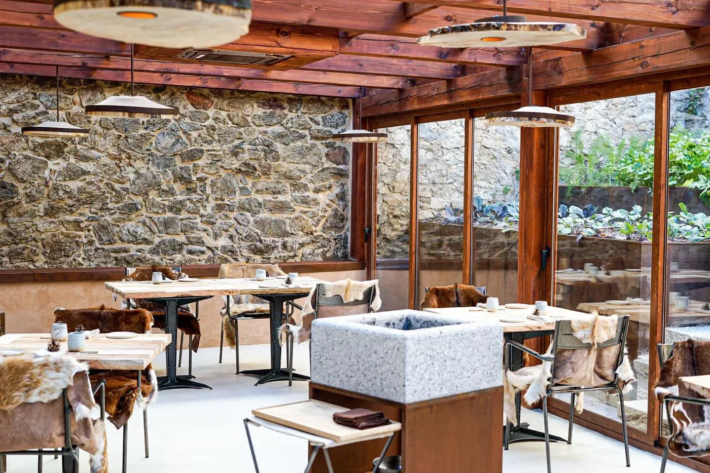 Cozy dining area at Montia restaurant in Madrid, featuring rustic decor and stone walls.