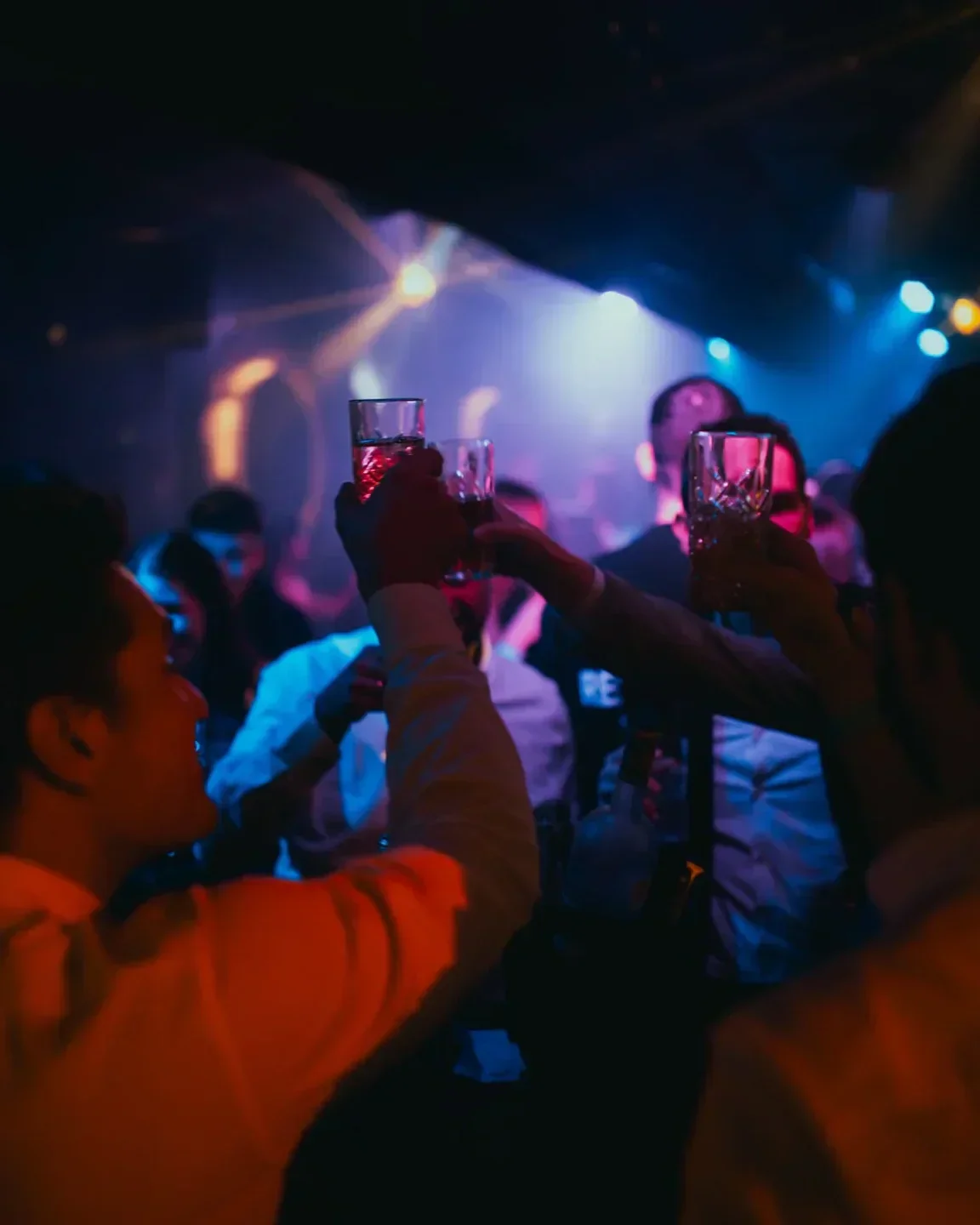 Cheers in MOONCLUB Prague, vibrant nightlife scene with friends, colorful lighting.