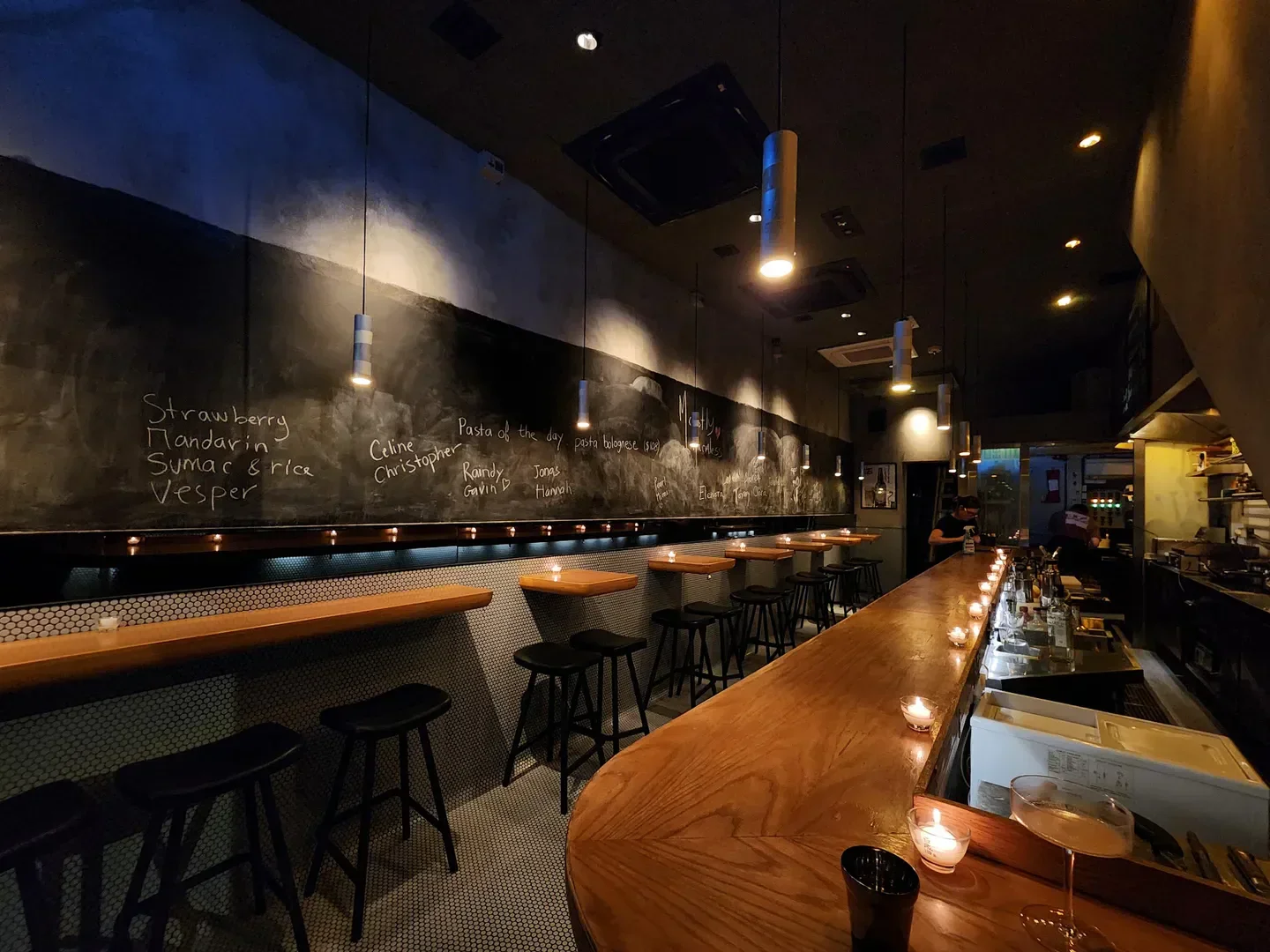 Cozy interior of Mostly Harmless Bar in Hong Kong, featuring a stylish bar and chalkboard menu.