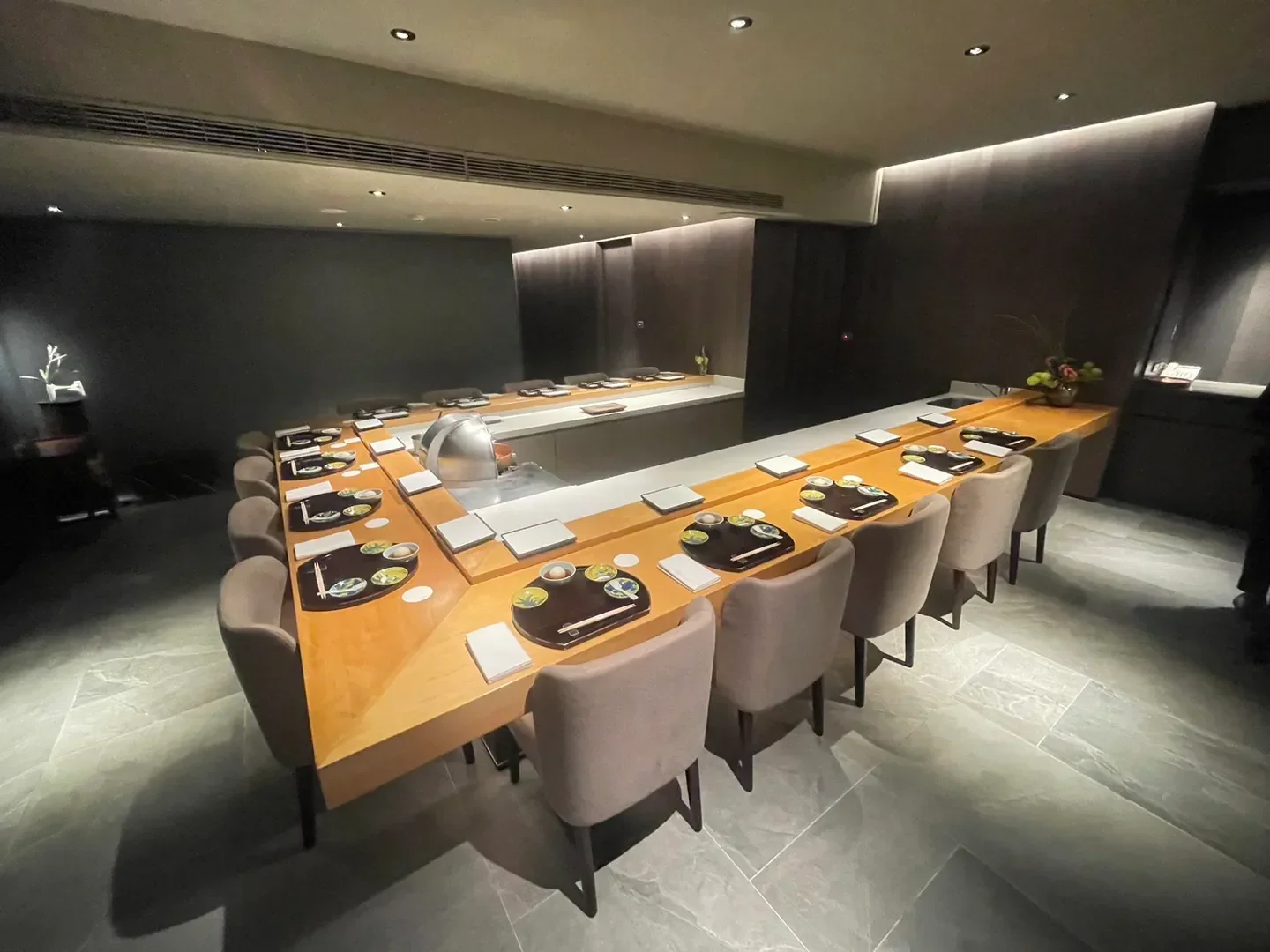 Elegant dining space at Mudan restaurant in Taipei, featuring a sushi bar and seating.