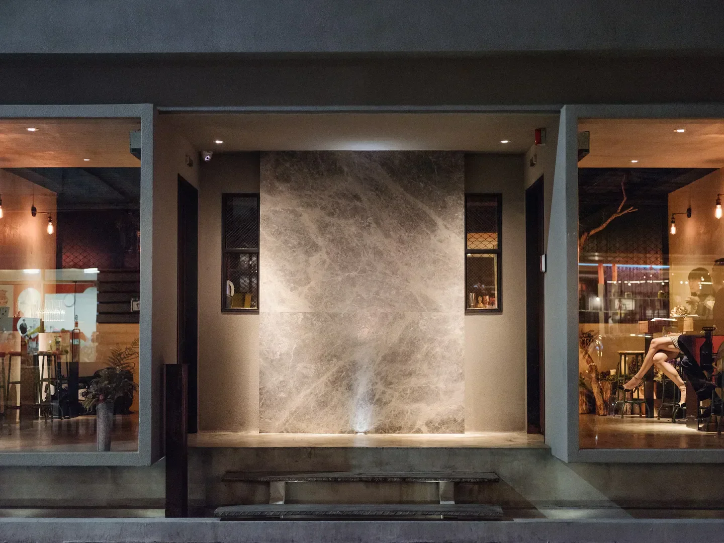 Entrance of MUME restaurant in Taipei, featuring elegant marble and warm interior lighting.