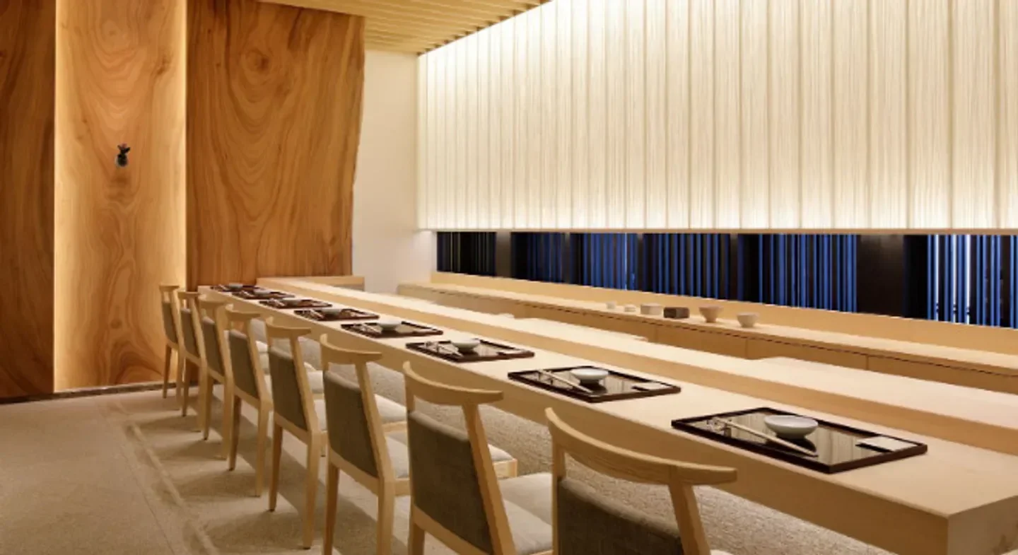 Minimalist dining area at Musashi by Aman in Tokyo, featuring wooden furniture and decor.