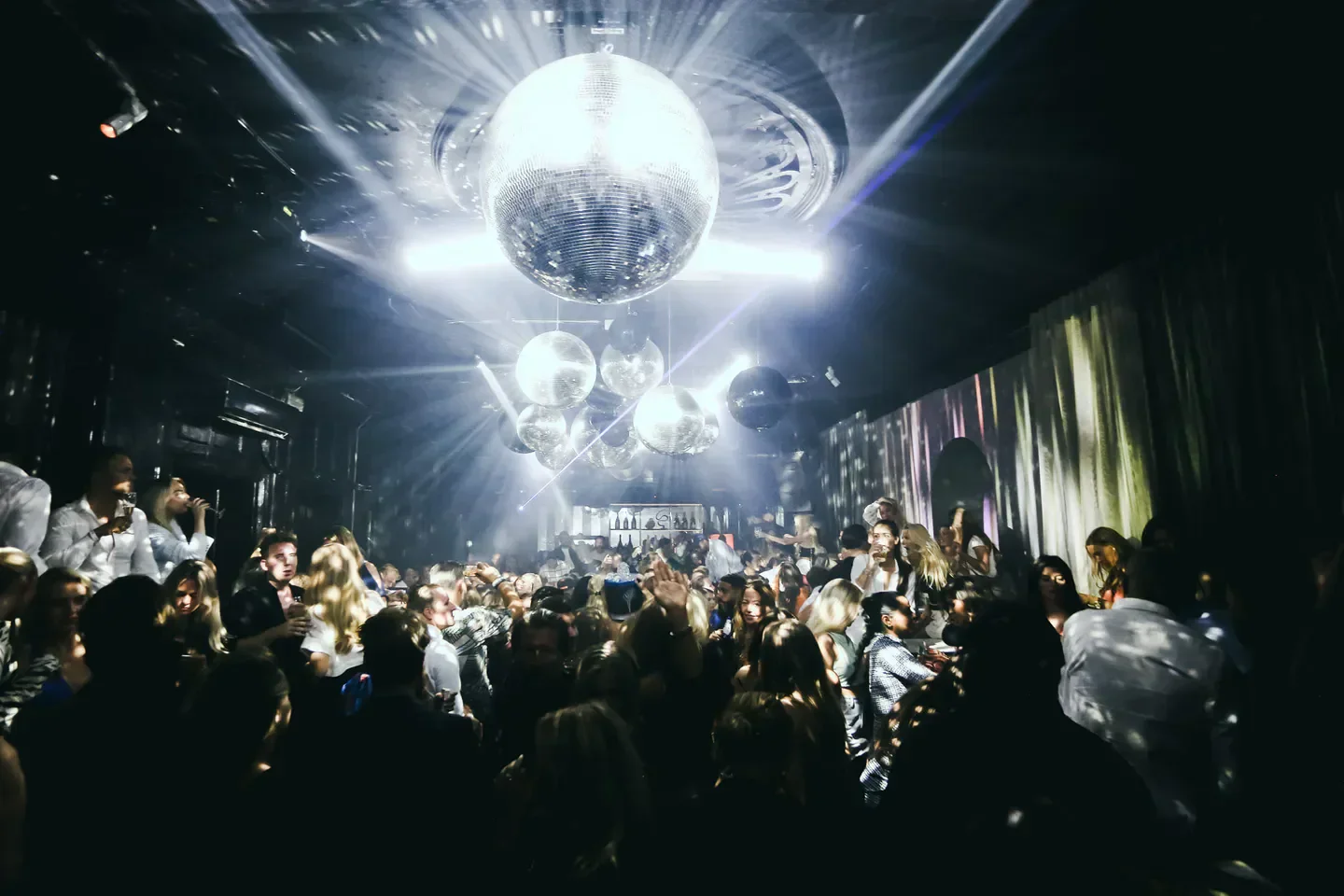 Disco ball lights at Museo nightclub in Copenhagen with dancing crowd.
