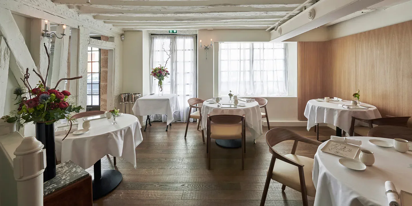 Elegant interior of Nakatani restaurant in Paris, with tables set for fine dining.