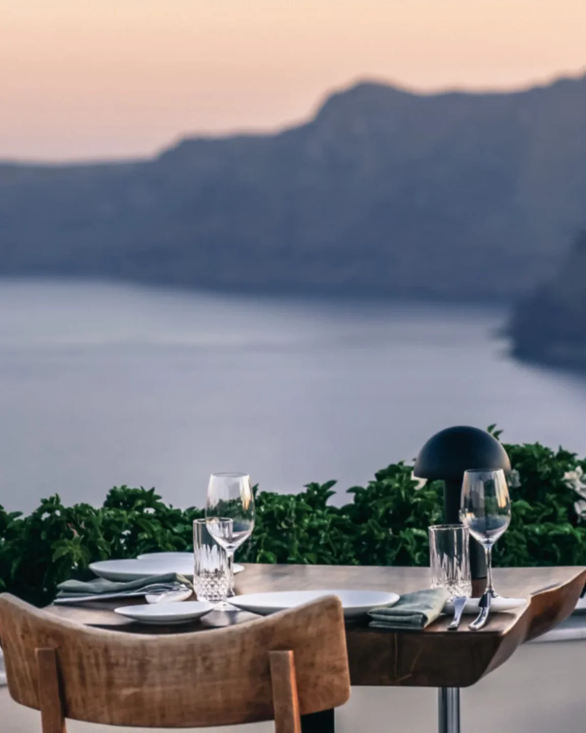 Elegant table setting at NAOS restaurant overlooking the city and sea at dusk
