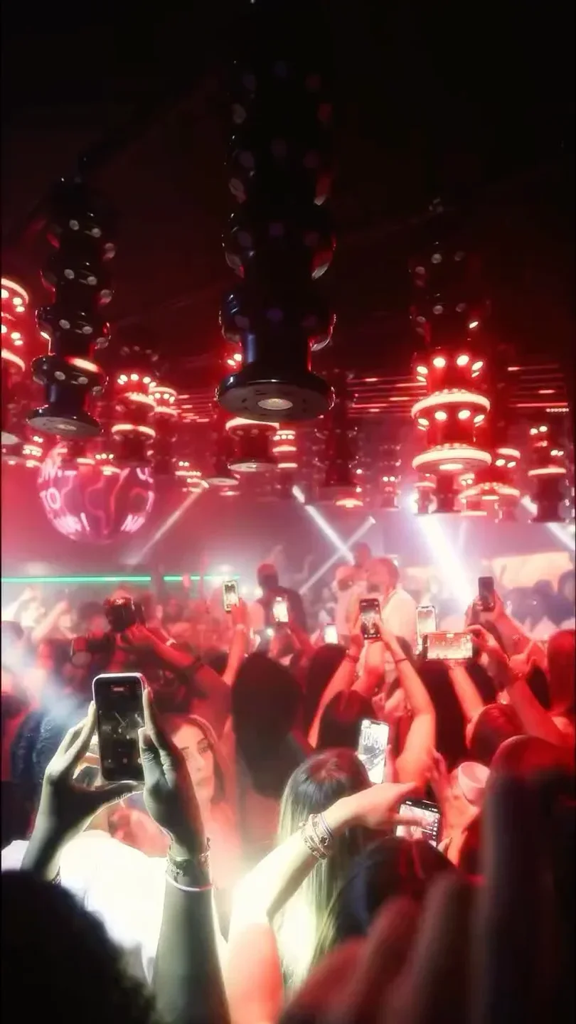 Crowd enjoying the vibrant atmosphere and red lighting at Naya Club Cannes in the city.