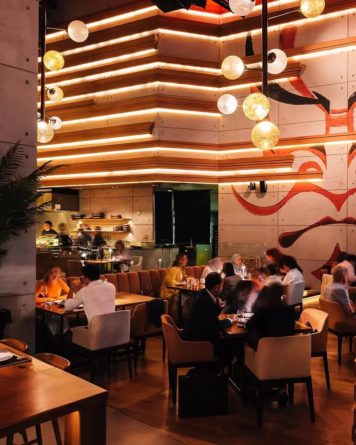 Interior of Netsu restaurant in Dubai with warm lighting and diners at tables.