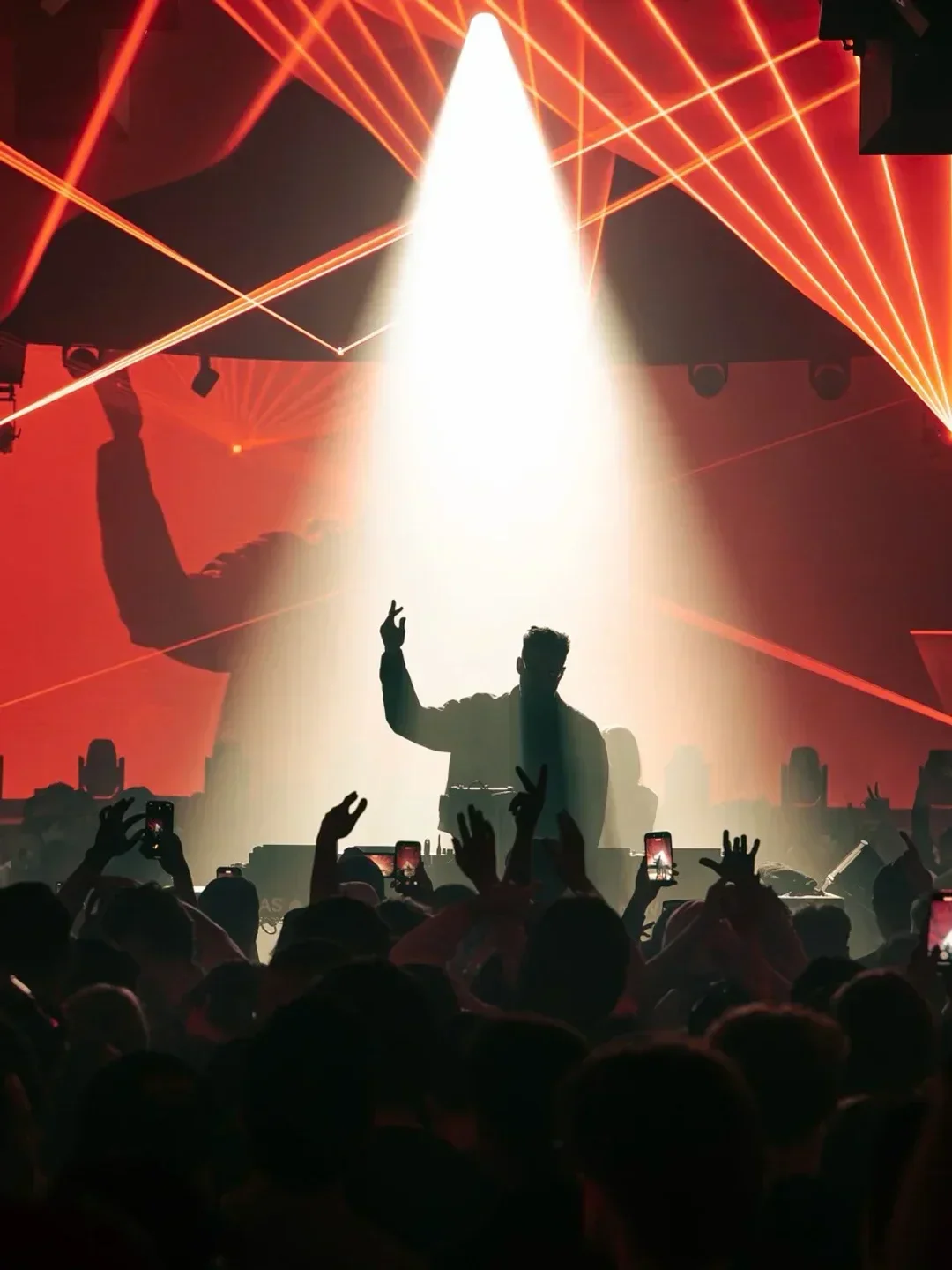Energetic crowd at New City Gas Montreal nightclub, illuminated by red stage lights.