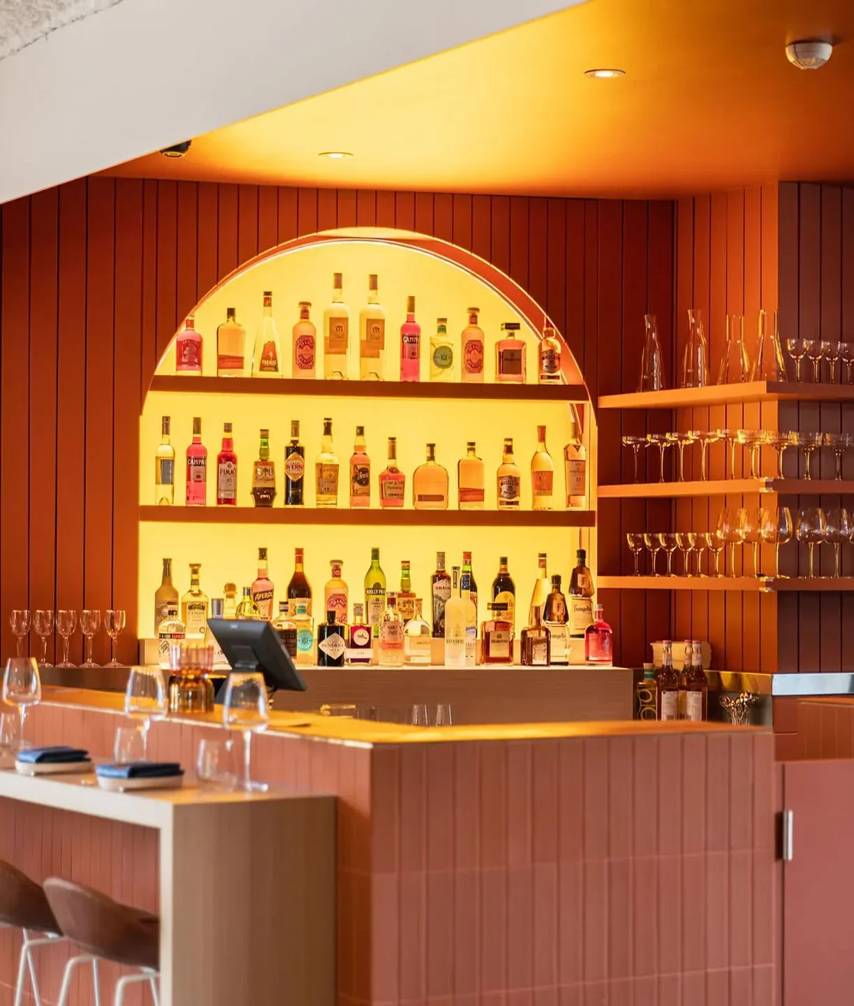 Stylish bar at Nico restaurant in Sydney, featuring a backlit liquor display.