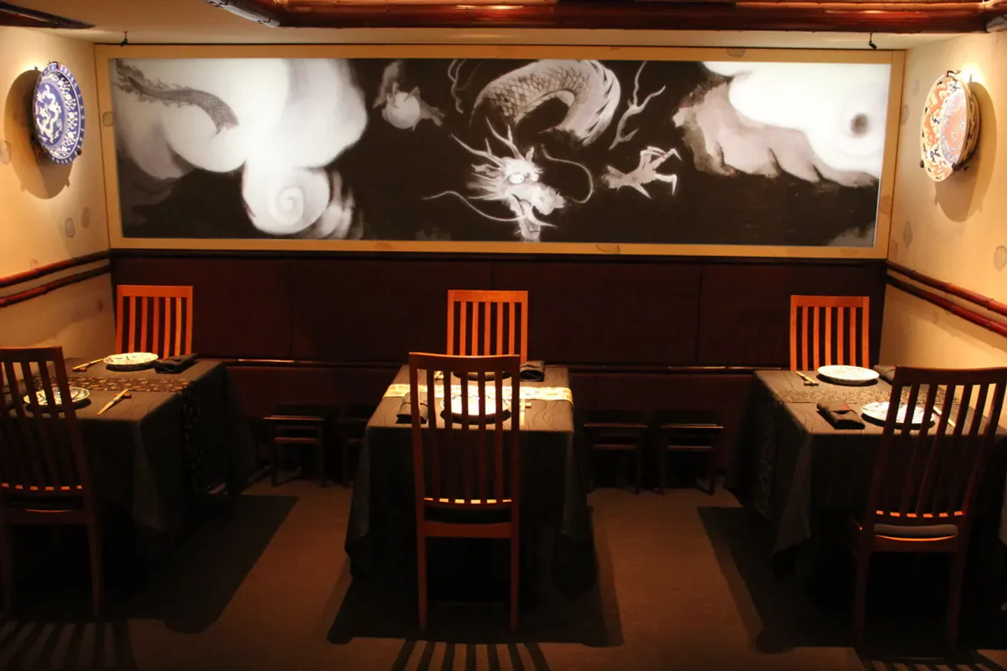 Elegant dining room interior at Nihonryori Ryugin restaurant in Tokyo with mural art.