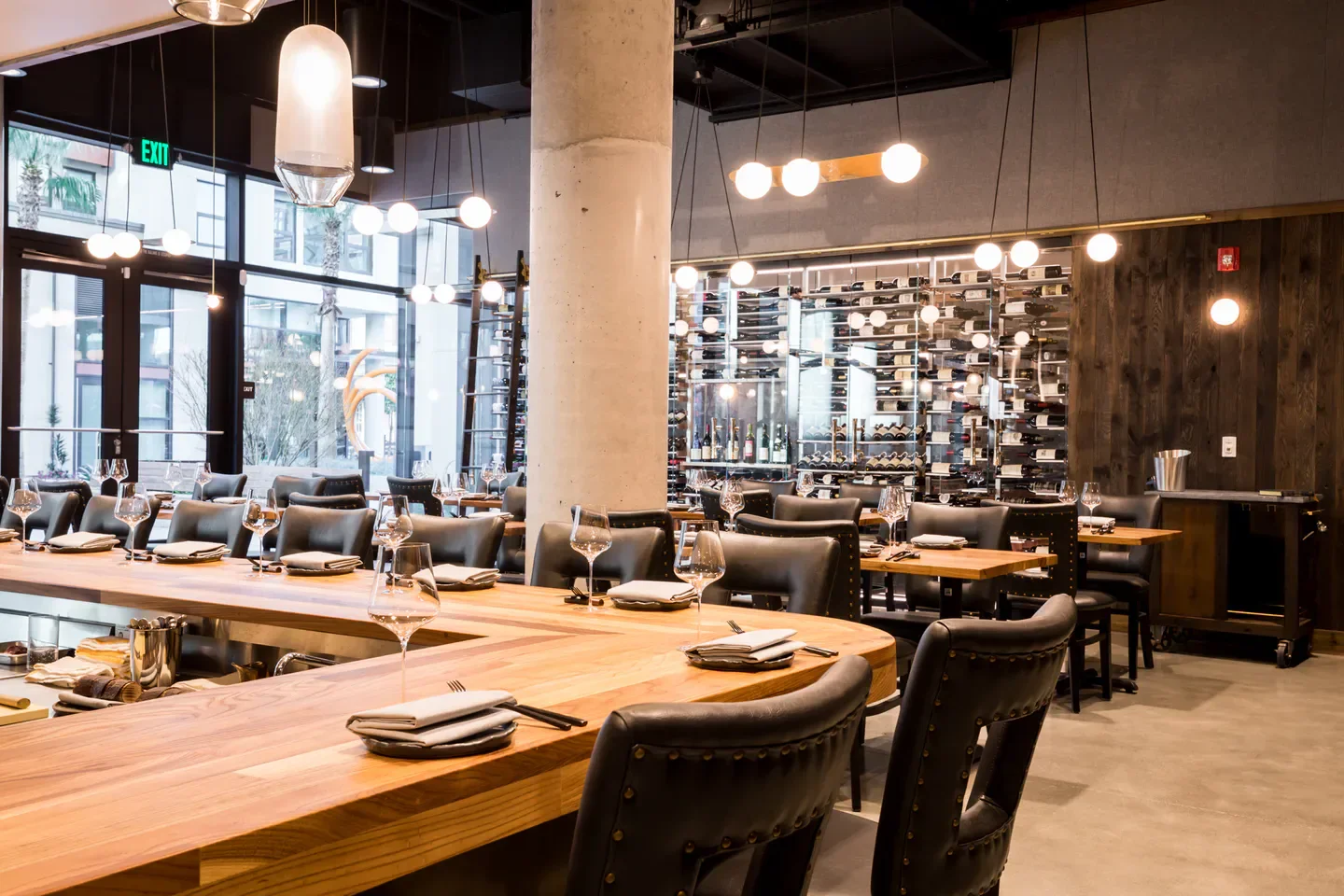 Elegant dining area at Niku Steakhouse in San Francisco, featuring wine display and seating.