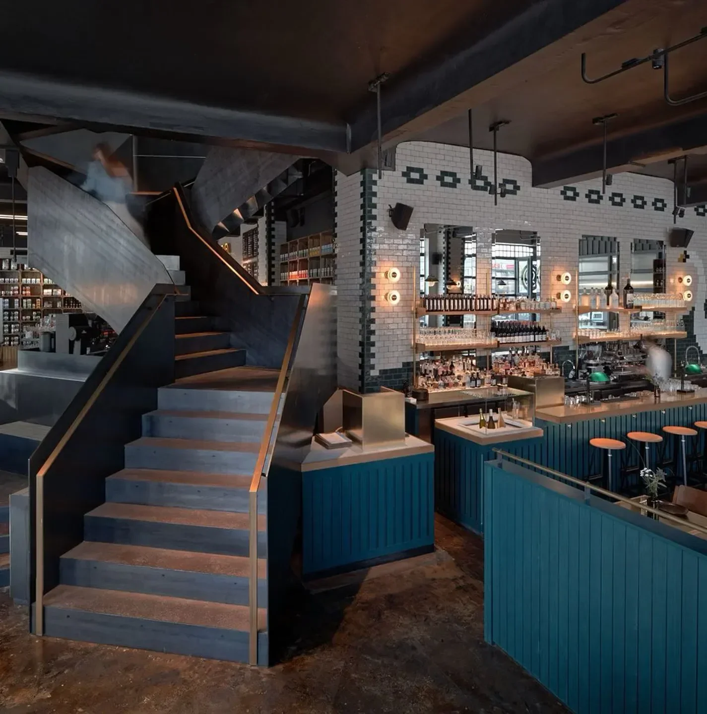 Interior of Nobelhart & Schmutzig restaurant in Berlin, featuring bar and staircase.