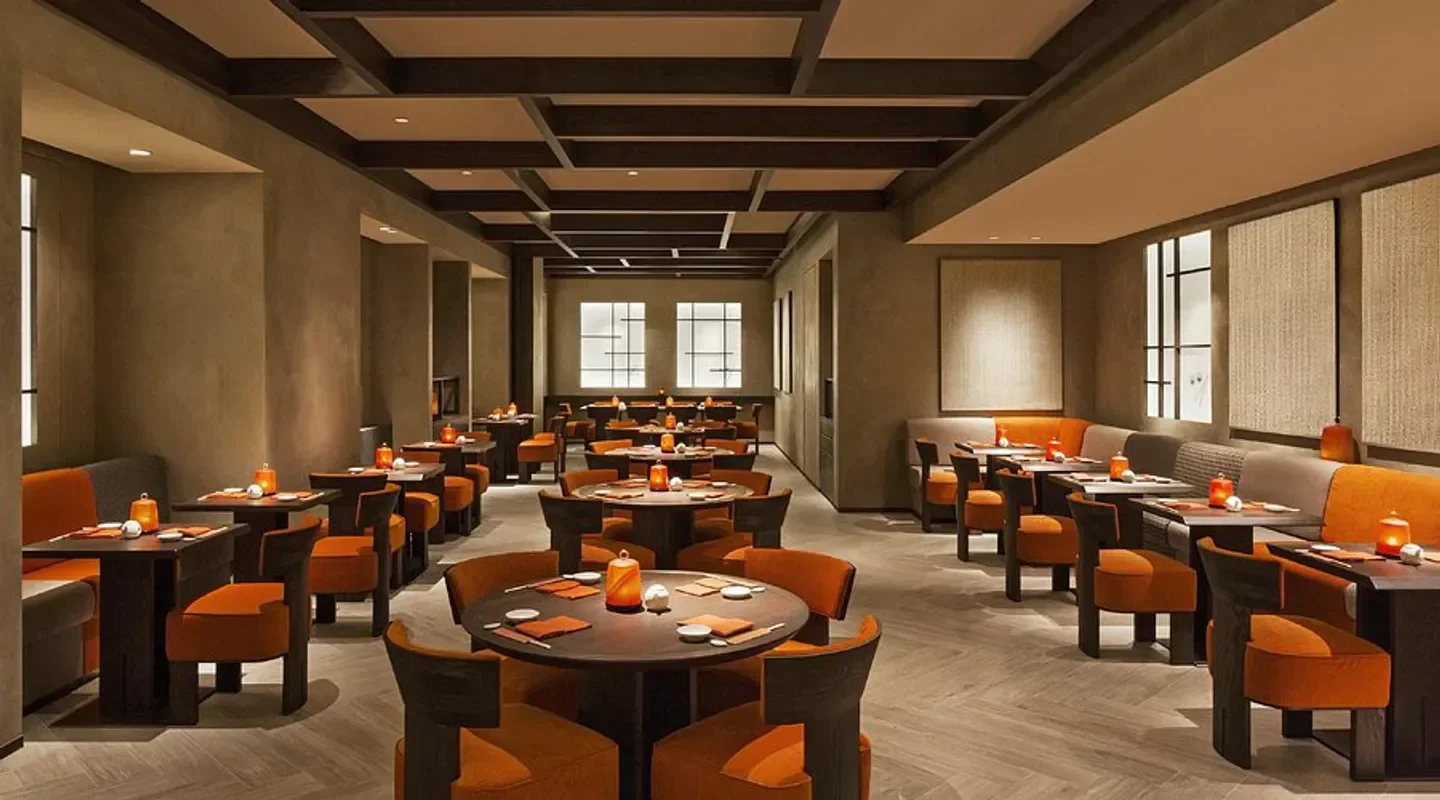 Interior of Nobu Milan restaurant with stylish orange seating and warm lighting