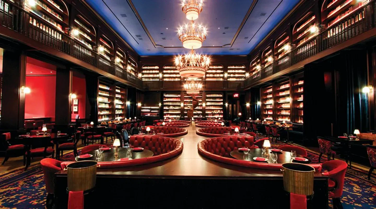 Interior of NoMad Library restaurant in Las Vegas, with bookshelves and red seating