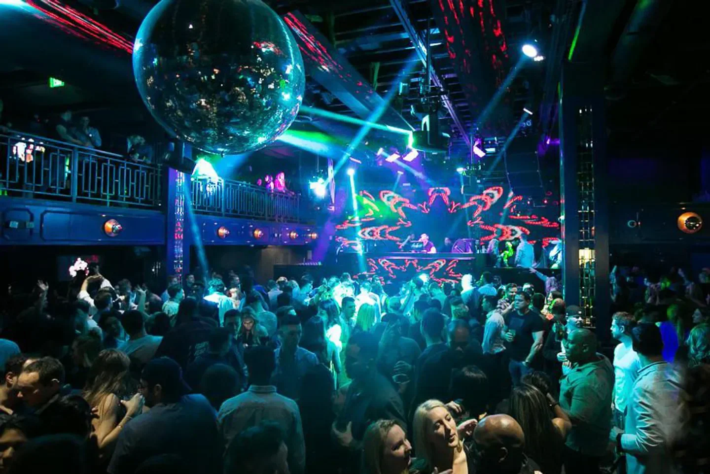 Energetic crowd at Noto Philadelphia nightclub, dancing under the disco ball and lights.