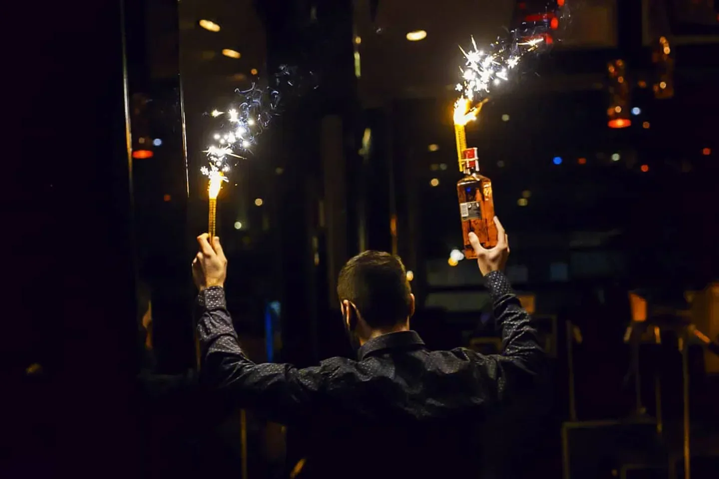 Bartender at Nubar Barcelona holding sparklers with a bottle, celebrating the night