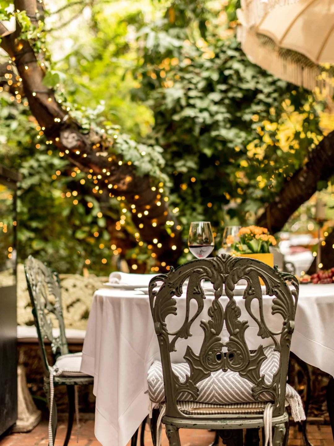 Romantic outdoor seating at Numa Pompilio restaurant in the city, adorned with fairy lights and elegant chairs.